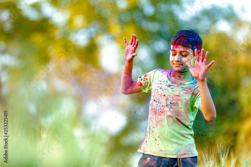 Indian child playing with the color in holi festival