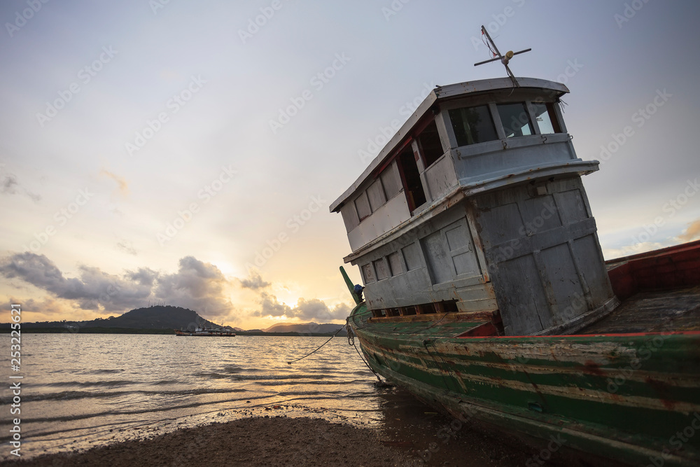 Obraz premium Old fishing boat at sunset