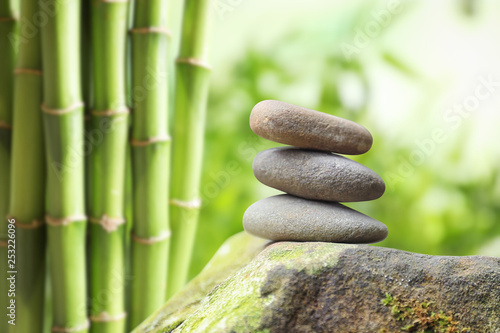 Balancing zen pebble stones outdoors against blurred background. Space for text