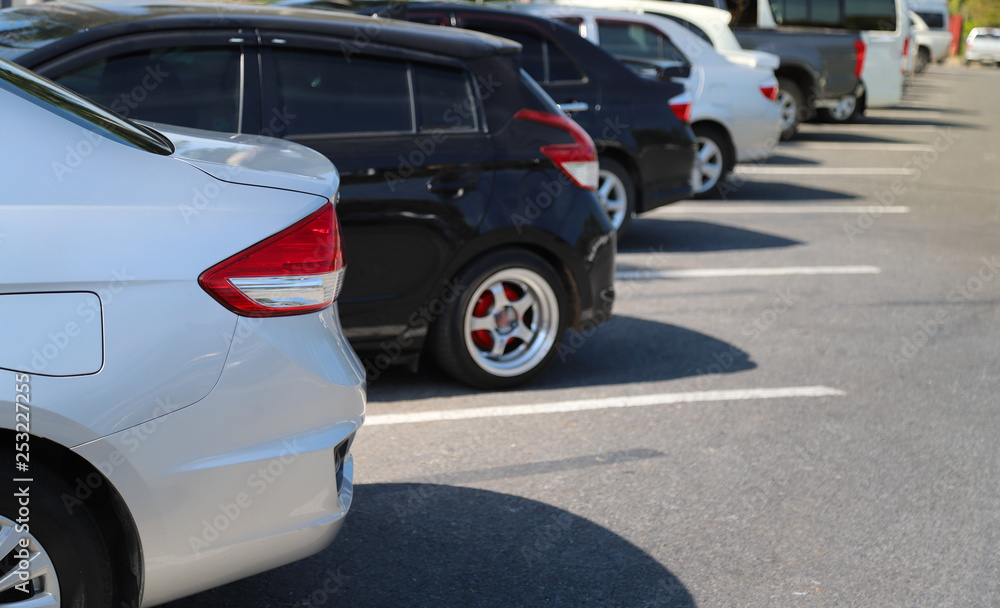 Closeup of back or rear car-light of blue car and other cars parking in outdoor parking area in bright sunny day. 