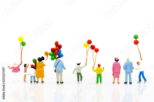 Miniature people: family and children enjoy with colorful balloons, happy family day concept.