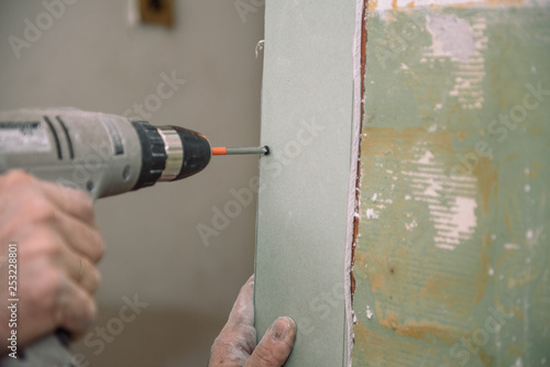 Tighten the screws. Screw the screws with the tool. Repair in the apartment. door installation. Locksmith work.