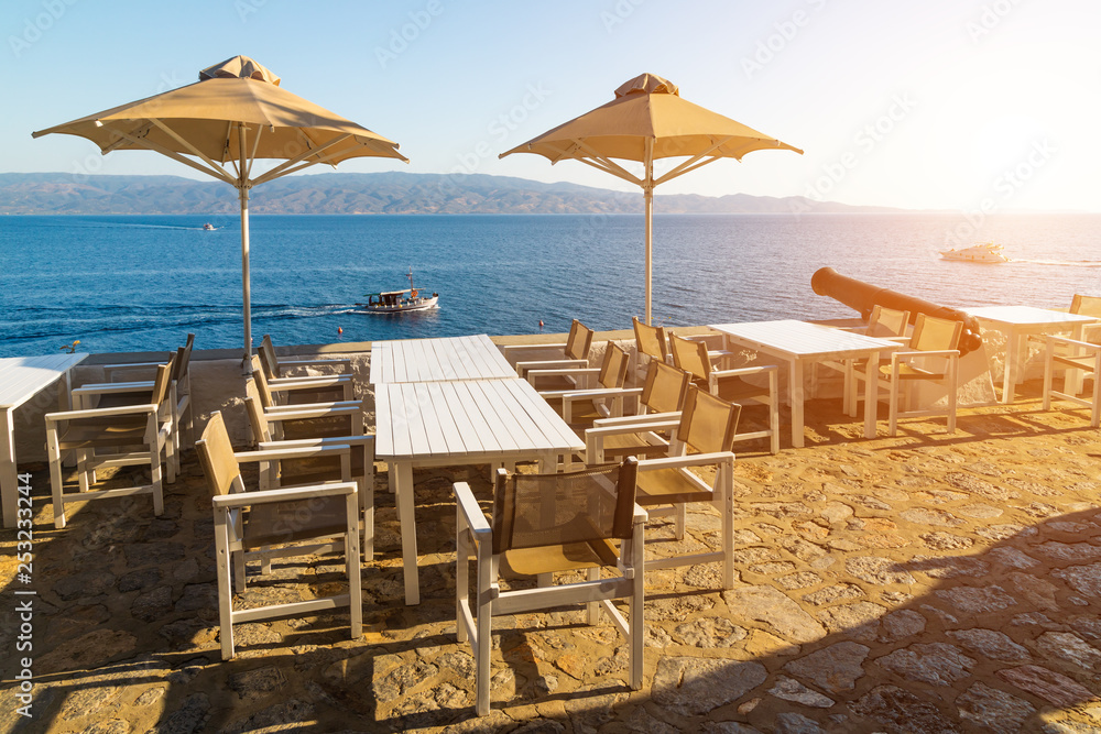 Cafe with umbrellas overlooking the sea. Hydra island, Greece.