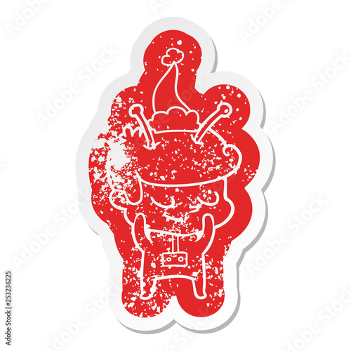 shy cartoon distressed sticker of a spaceman wearing santa hat