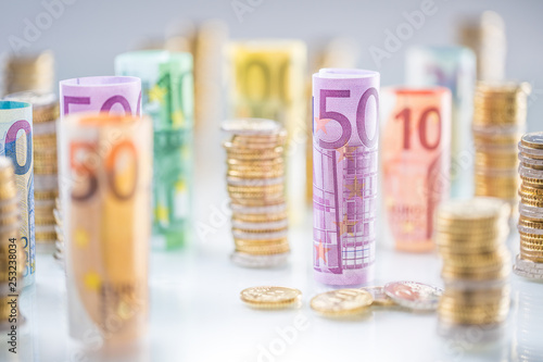 Rolled euro banknotes and coins towers stacked in other positions