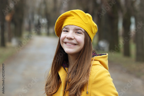 beautiful teenage girl in a yellow coat and beret portrait