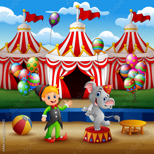 Circus elephant and trainer on the arena with circus tent background