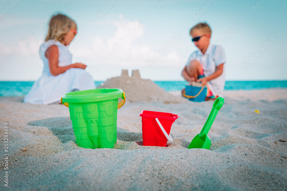 toys and kids-boy and girl- play with sand on beach toys and kids-boy and girl- play with sand on beach
