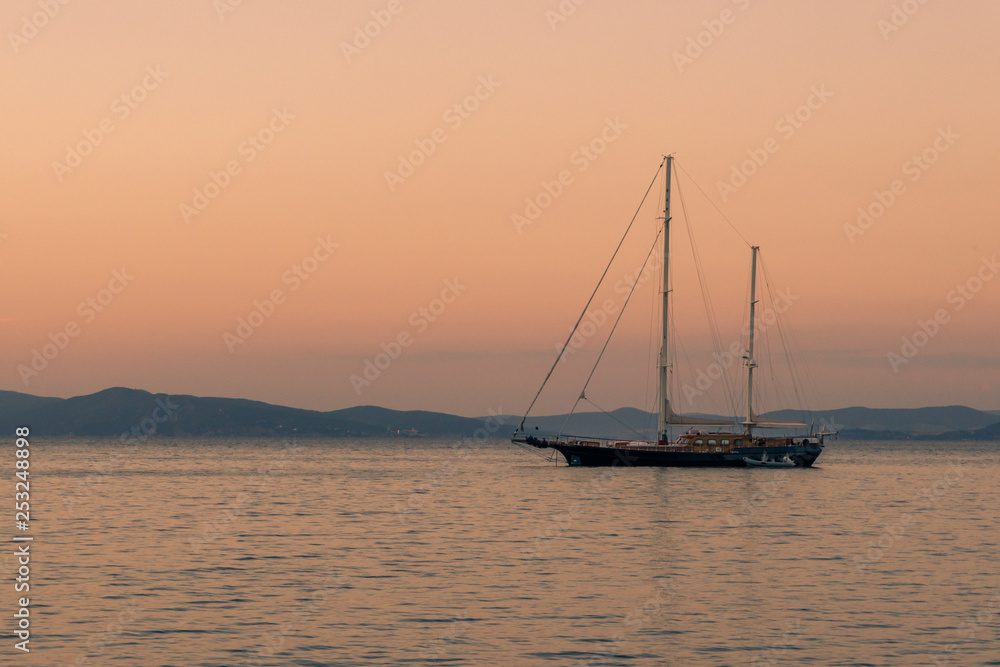 Silhouette of yacht on the background of orange sunset