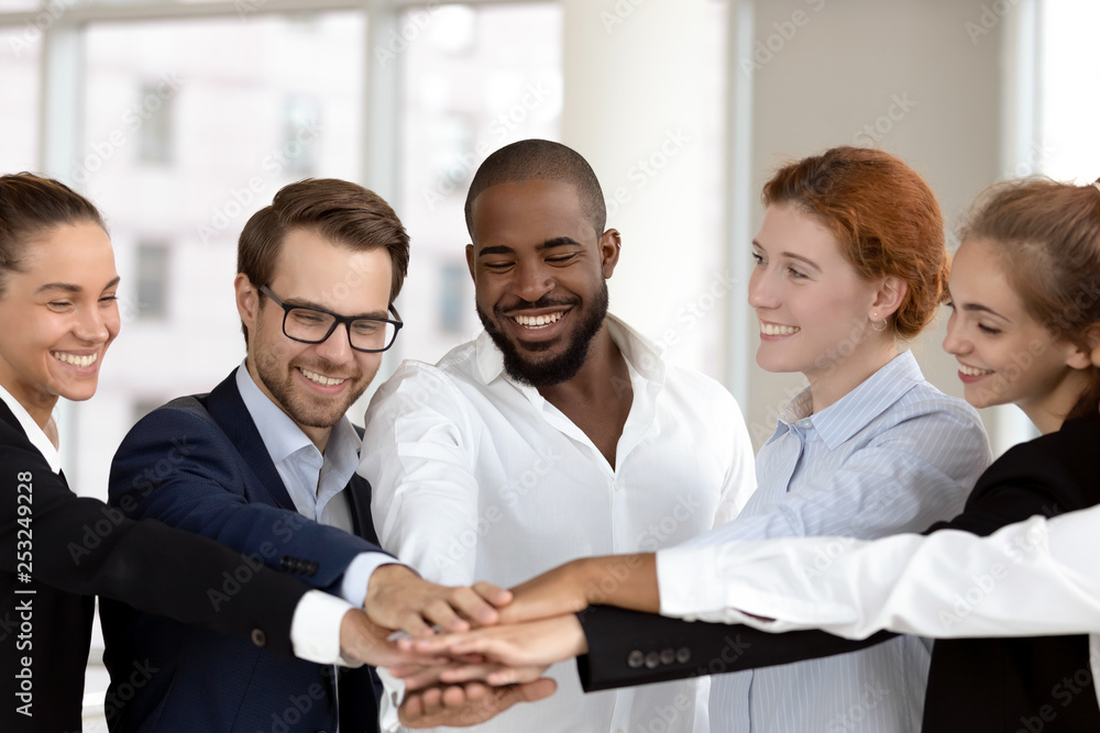 Diverse business people group put hands together in stack pile Diverse business people group put hands together in stack pile