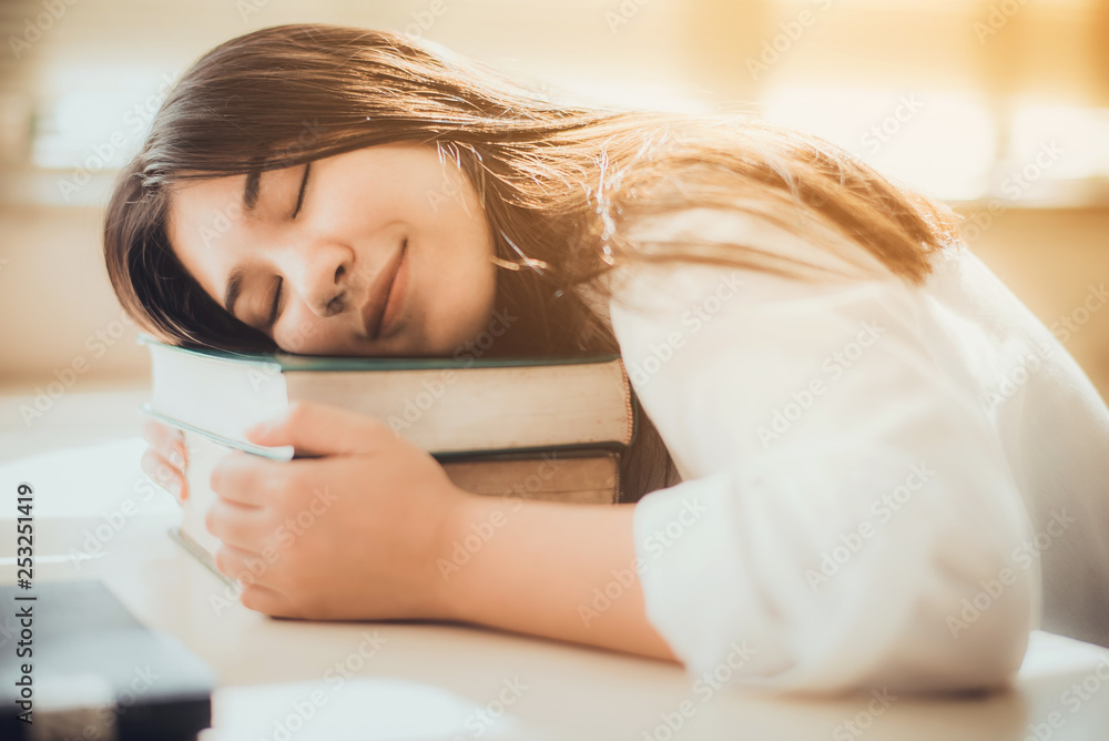 Obraz premium Young Asian woman is sleeping on the books at library
