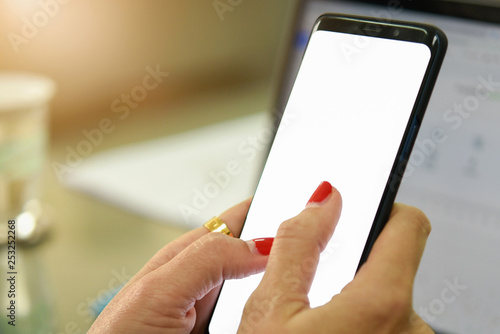 Woman holding smart phone with bank moblie can be add your texts or others. at office photo