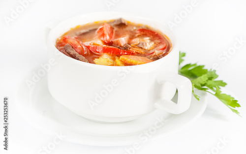 Bowl with delicious soup with meat on white