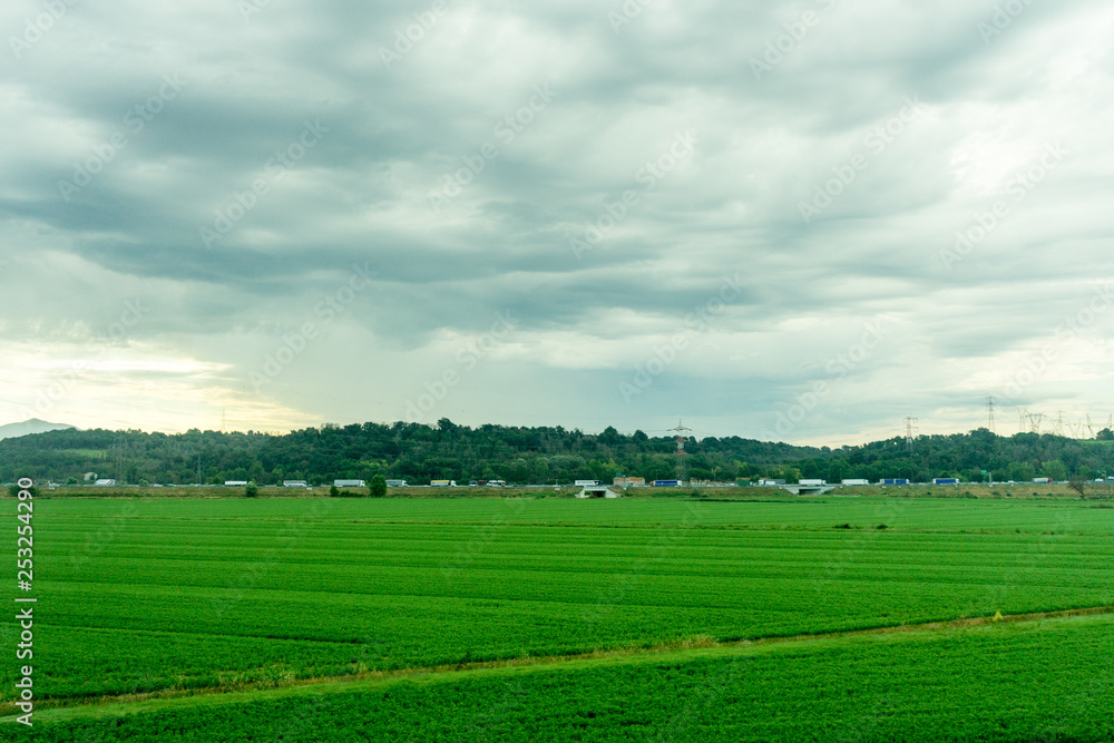 Village green field seen on the train journey from Rome to Florence in the morning during sunrise