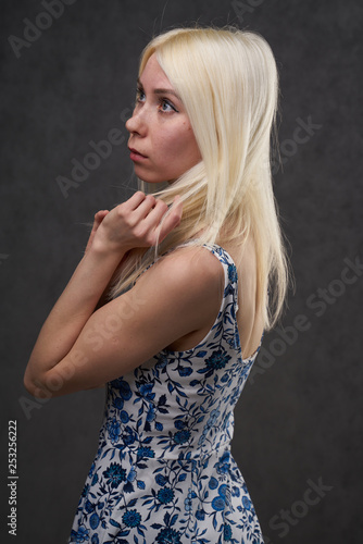beauty female blond in blue dress on gray background