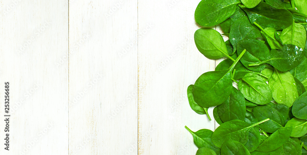 Fresh green spinach leaves on white wooden rustic background top view copy space. Baby young spinach leaves, Ingredient for salad, healthy food, diet. Nutrition concept. Fresh green spinach leaves on white wooden rustic background top view copy space. Baby young spinach leaves, Ingredient for salad, healthy food, diet. Nutrition concept.