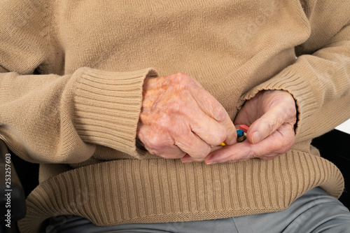 Elderly hands holding pills