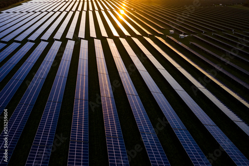 Aerial looking over a modern solar farm at sunrise in the English countryside