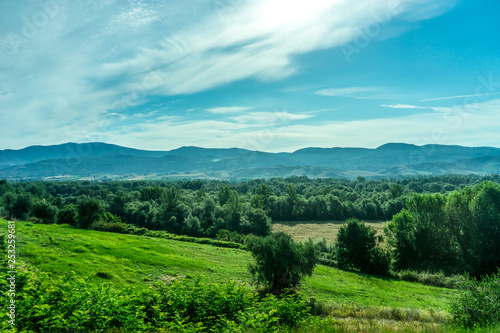 Italy, Rome to Florence train, a large green field with a mountain in the background