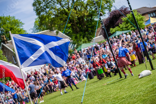 Bild auf Leinwand Traditional Scottish Highland Games with athletes in kilts and national flags –