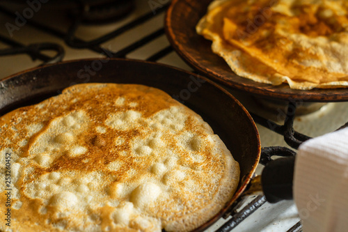 Thin pancakes in a pan on the stove