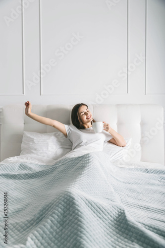 Attractive woman stretching at the bed in the morning