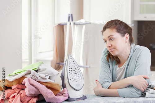  Pretty young woman housewife ironing clean washed things.