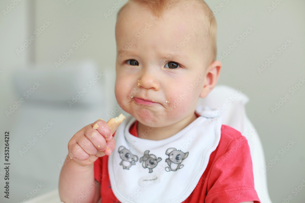 Cute little boy eating his first baby food