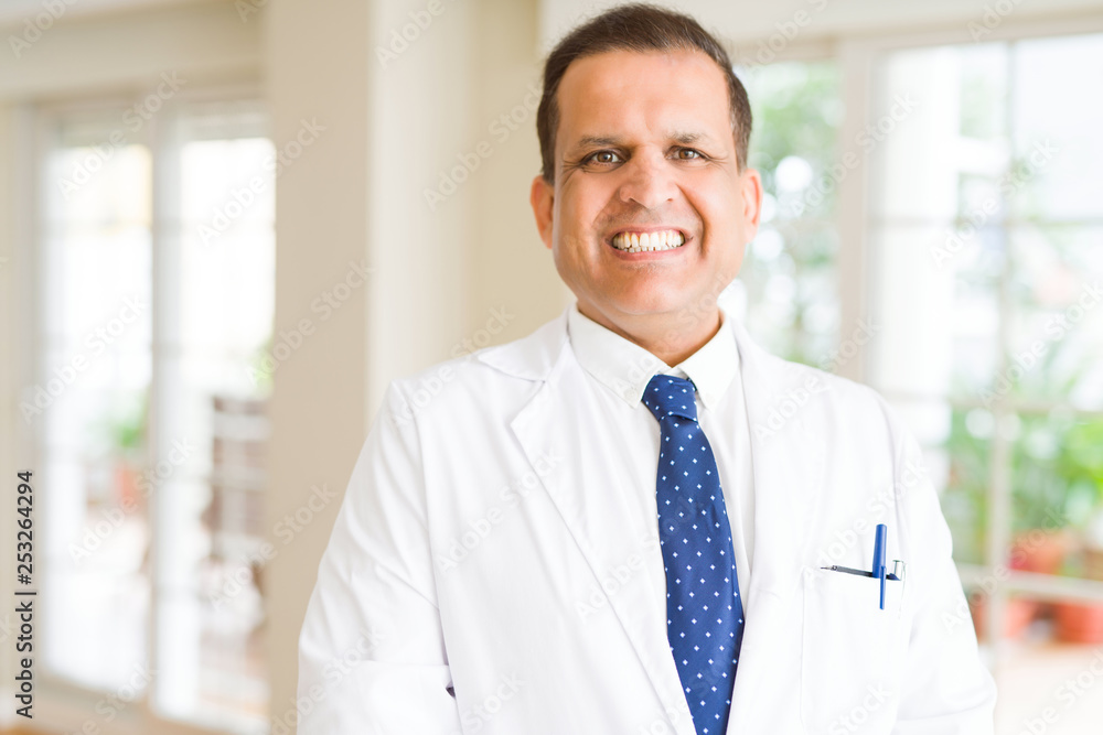 Fototapeta premium Middle age man wearing white medical coat and smiling