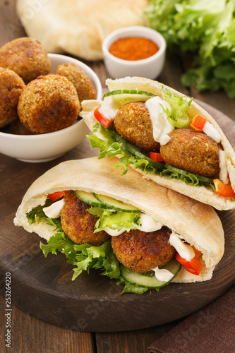 Falafel and fresh vegetables in pita bread with sauce.