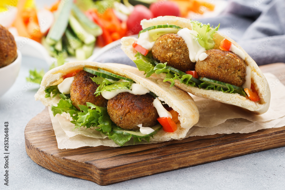 Healthy vegetarian falafel pita with fresh vegetables and sauce - obrazy, fototapety, plakaty 