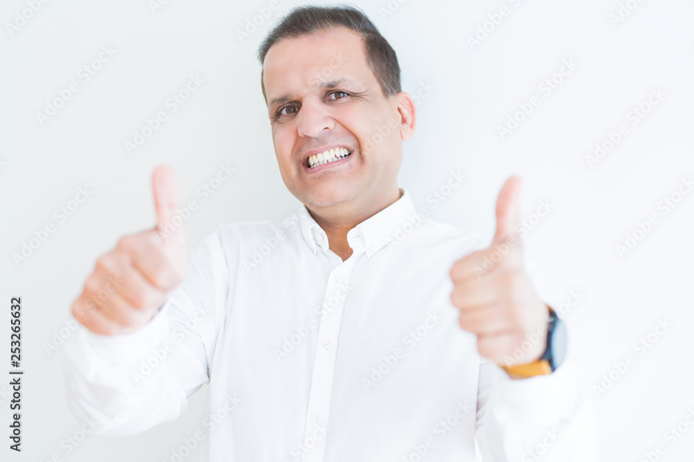Middle age man doing postive gesture with thumbs up smiling to the camera Middle age man doing postive gesture with thumbs up smiling to the camera
