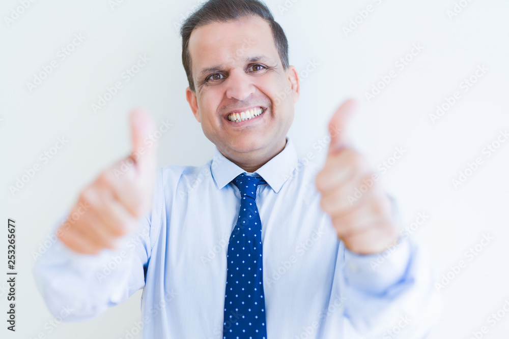 Middle age man doing postive gesture with thumbs up smiling to the camera Middle age man doing postive gesture with thumbs up smiling to the camera