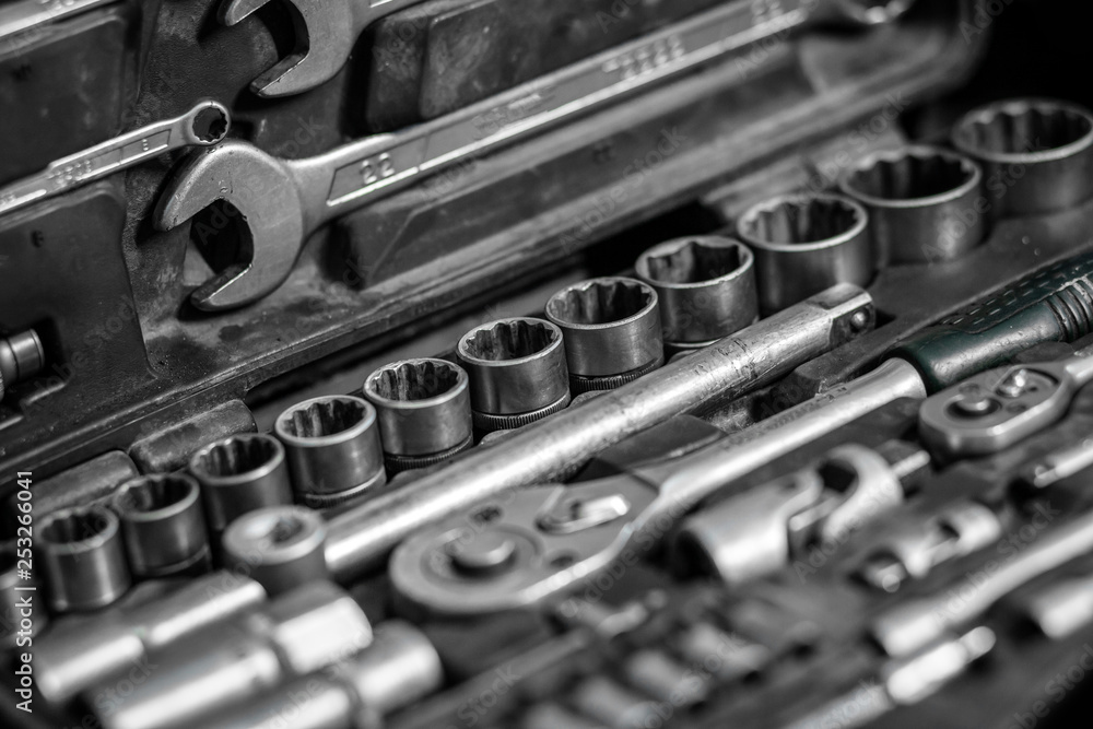 Fototapeta premium Flat Lay metal tools: wrenches, ratchet, a set of interchangeable heads of different sizes and other tools are in the tool box, a top view. Close-up Carpenter's Tool Kit