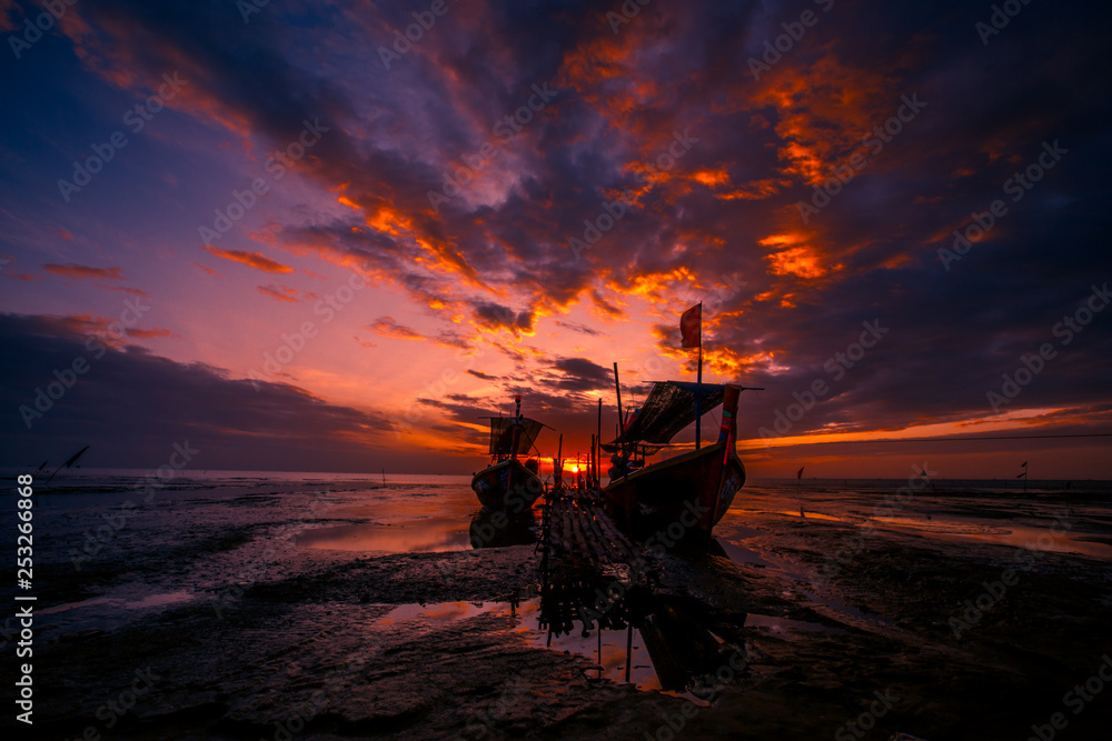 Obraz premium The background of the fishing boats is docked at the beach, with colorful skies in the morning, the natural beauty and the coexistence of fishermen on the waterfront