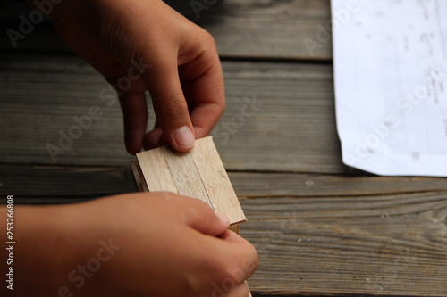 Child's hand, fold and stick a wooden toy