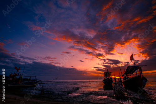 The background of the fishing boats is docked at the beach  with colorful skies in the morning  the natural beauty and the coexistence of fishermen on the waterfront