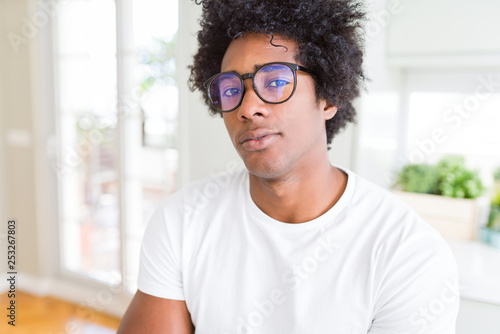 African American man wearing glasses Relaxed with serious expression on face. Simple and natural with crossed arms