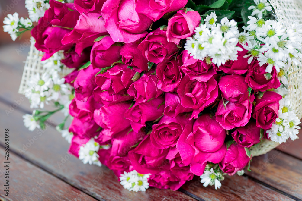 The view of the pink rose bouquet close-up,arranged on wooden table,be used to display,to various festivals(Valentine,wedding,New Year's party,birthday party)or to decorate in Restaurant,coffee shop