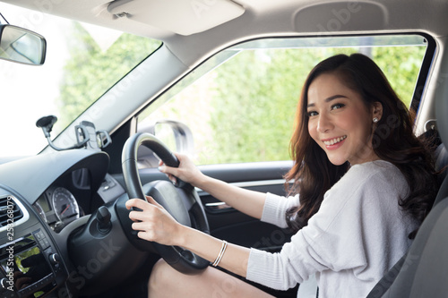 Asian women driving a car and smile happily with glad positive expression during the drive to travel journey, People enjoy laughing and relaxed happy woman on road trip vacation concept, Thai model © comzeal