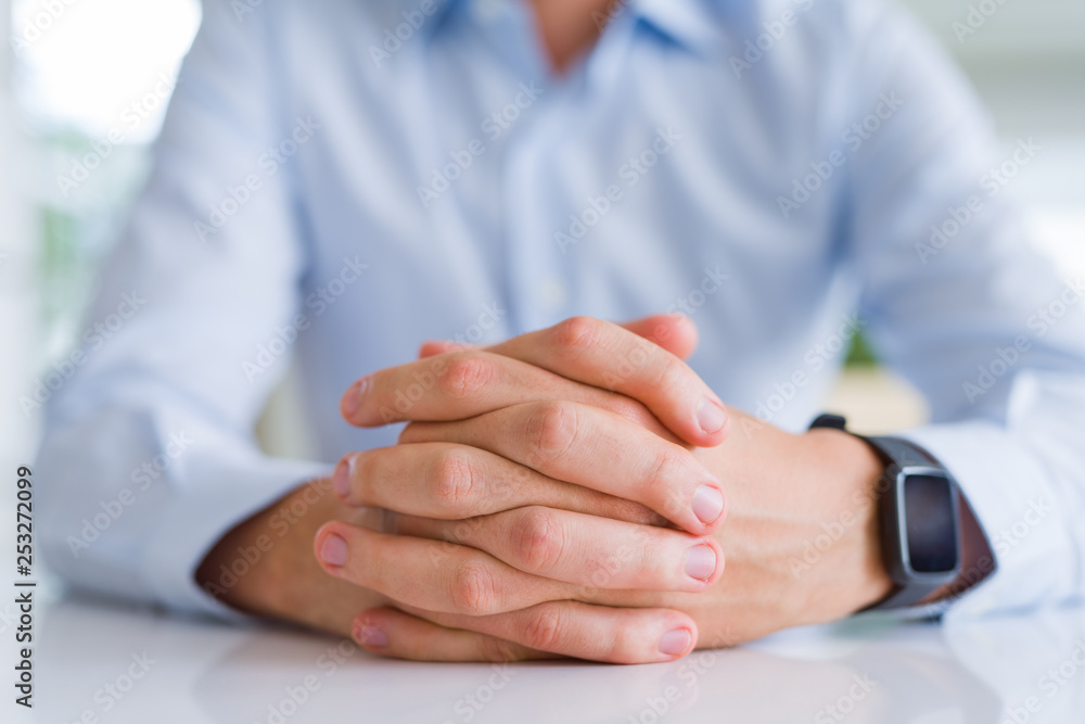 Obraz premium Close up of man crossed hands over white table