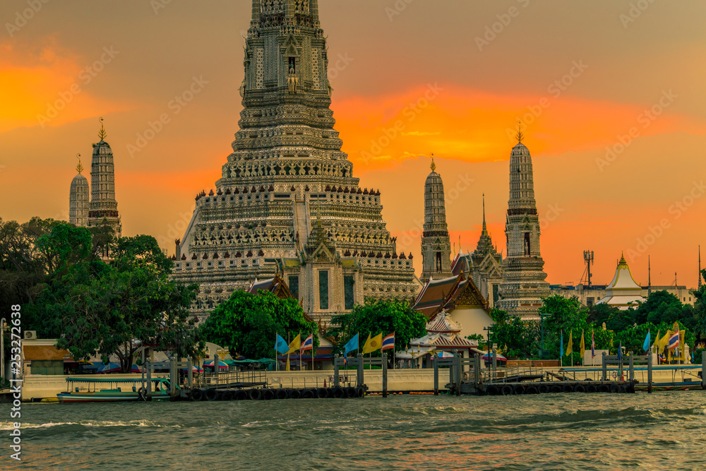 Obraz premium Twilight wallpaper in the evening,the sun going back to the horizon,Wat Arun Ratchawaramaram is a temple along the ChaoPhraya River is an important place and a beautiful tourist destination in Bangkok