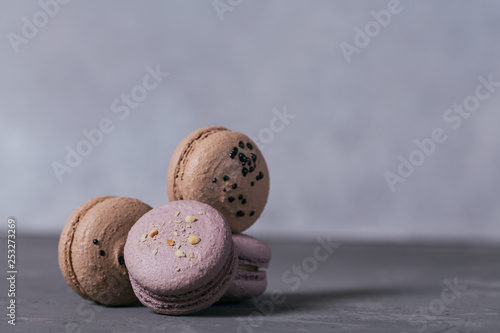 Heap of sweet french macaroons on grey concrete background
