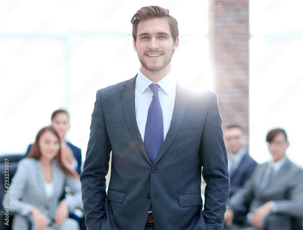 Handsome businessman smiling with his colleagues behind Handsome businessman smiling with his colleagues behind