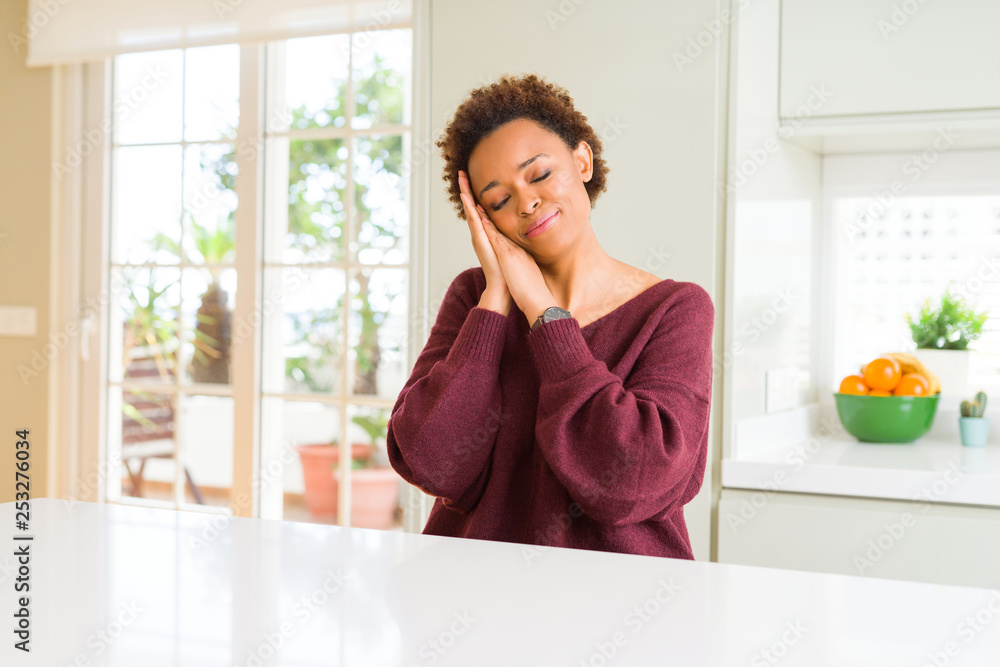 Young beautiful african american woman at home sleeping tired dreaming and posing with hands together while smiling with closed eyes. Young beautiful african american woman at home sleeping tired dreaming and posing with hands together while smiling with closed eyes.