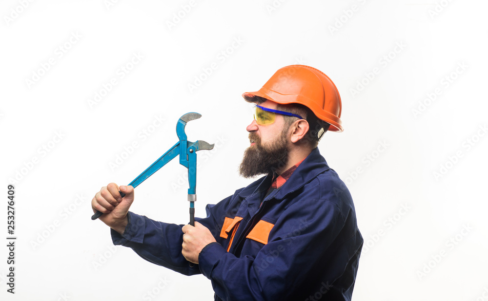 Bearded worker with tools in hand. Repair tools. Repair service. Worker in helmet with pipe wrench. Bearded man in construction helmet. Uniform. Mechanic. Plumbing and renovation. Bearded worker with tools in hand. Repair tools. Repair service. Worker in helmet with pipe wrench. Bearded man in construction helmet. Uniform. Mechanic. Plumbing and renovation.