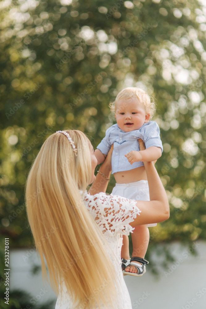 Young blond hair mom play with son outside. Little boy with blond hair.  Happy family Stock Photo | Adobe Stock