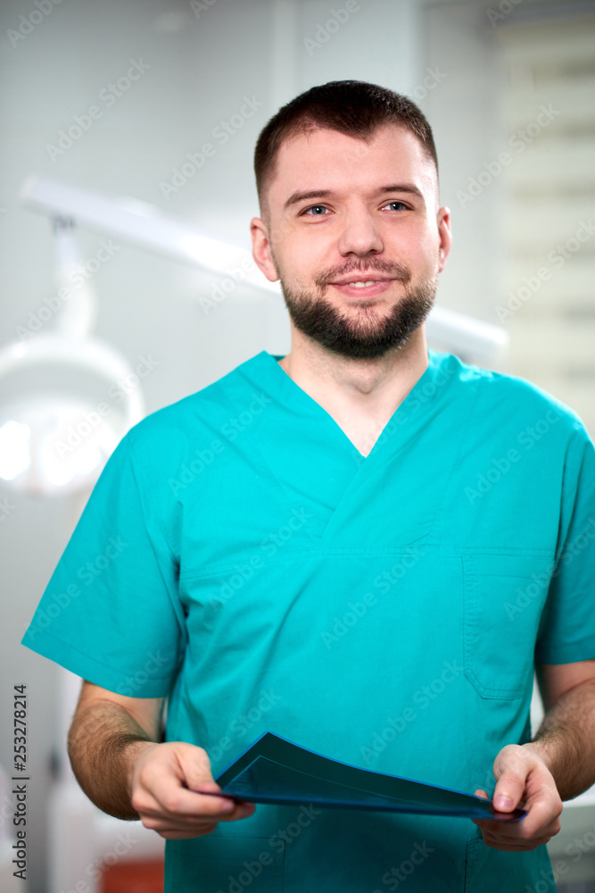 Caucasian male dentist holding xray in hands and smiling Caucasian male dentist holding xray in hands and smiling