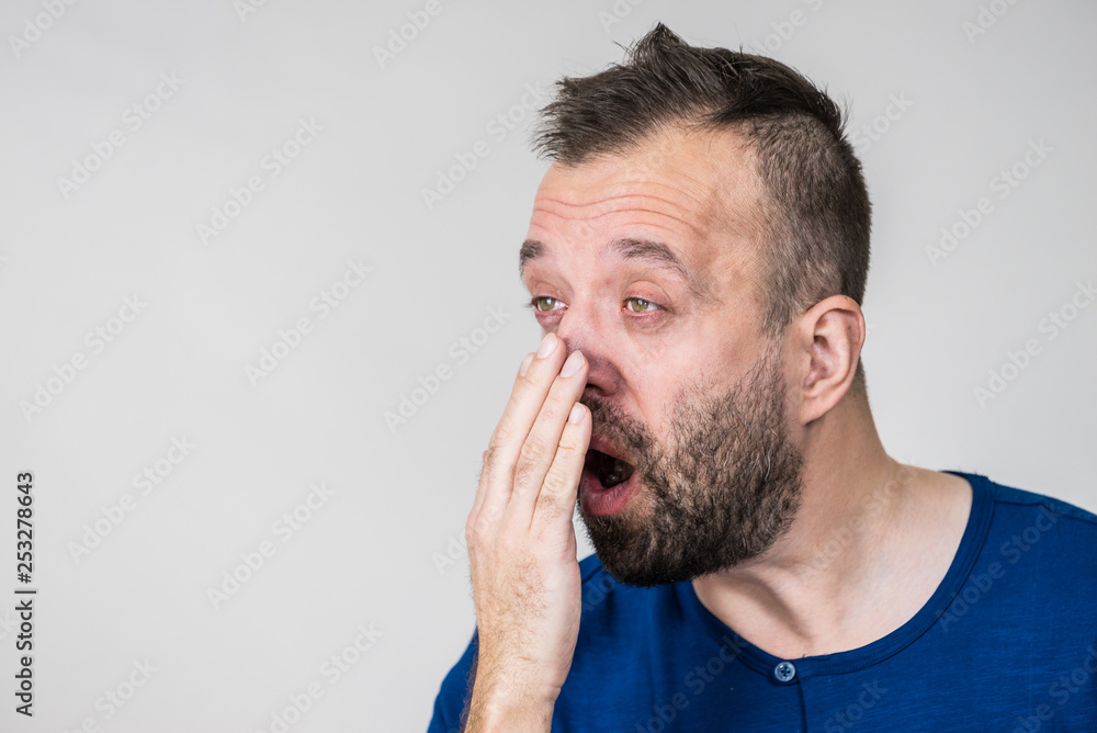 Man examing his breath smell Man examing his breath smell
