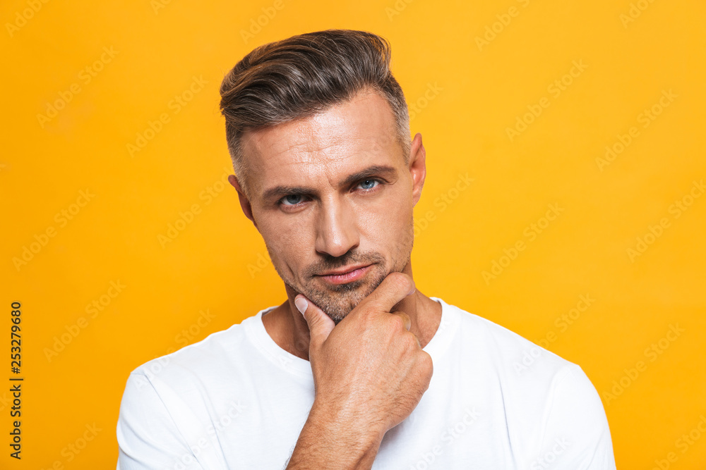 Handsome serious man posing isolated over yellow wall background. Handsome serious man posing isolated over yellow wall background.